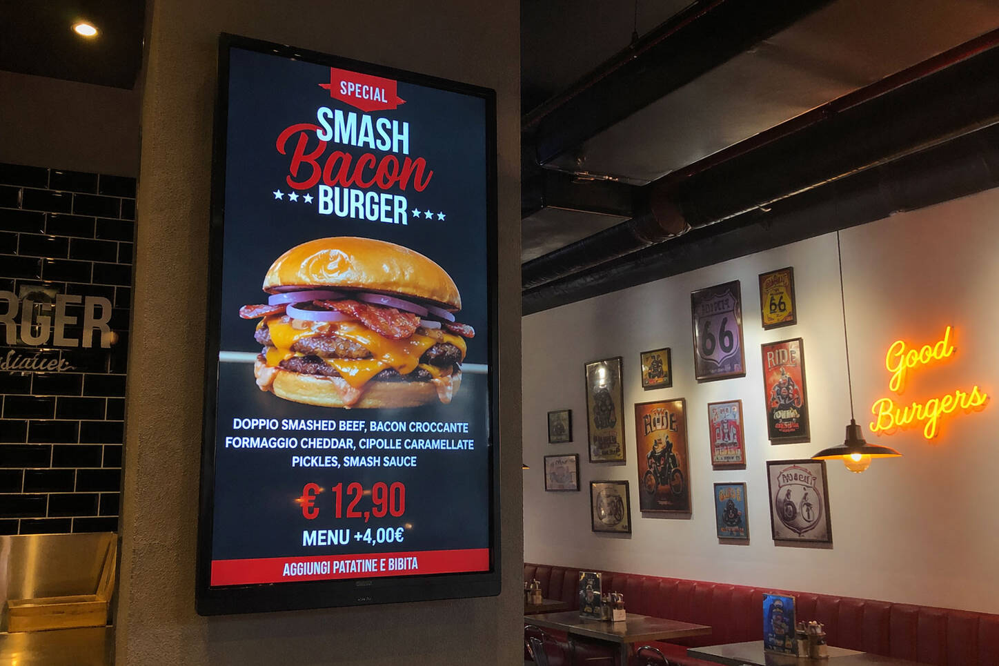 Schermo digital signage verticale in un ristorante che promuove uno Smash Bacon Burger con foto, ingredienti e prezzo.